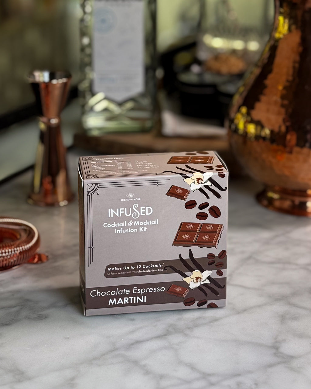 Chocolate Espresso Martini cocktail kit on a marble surface with blurred bar background